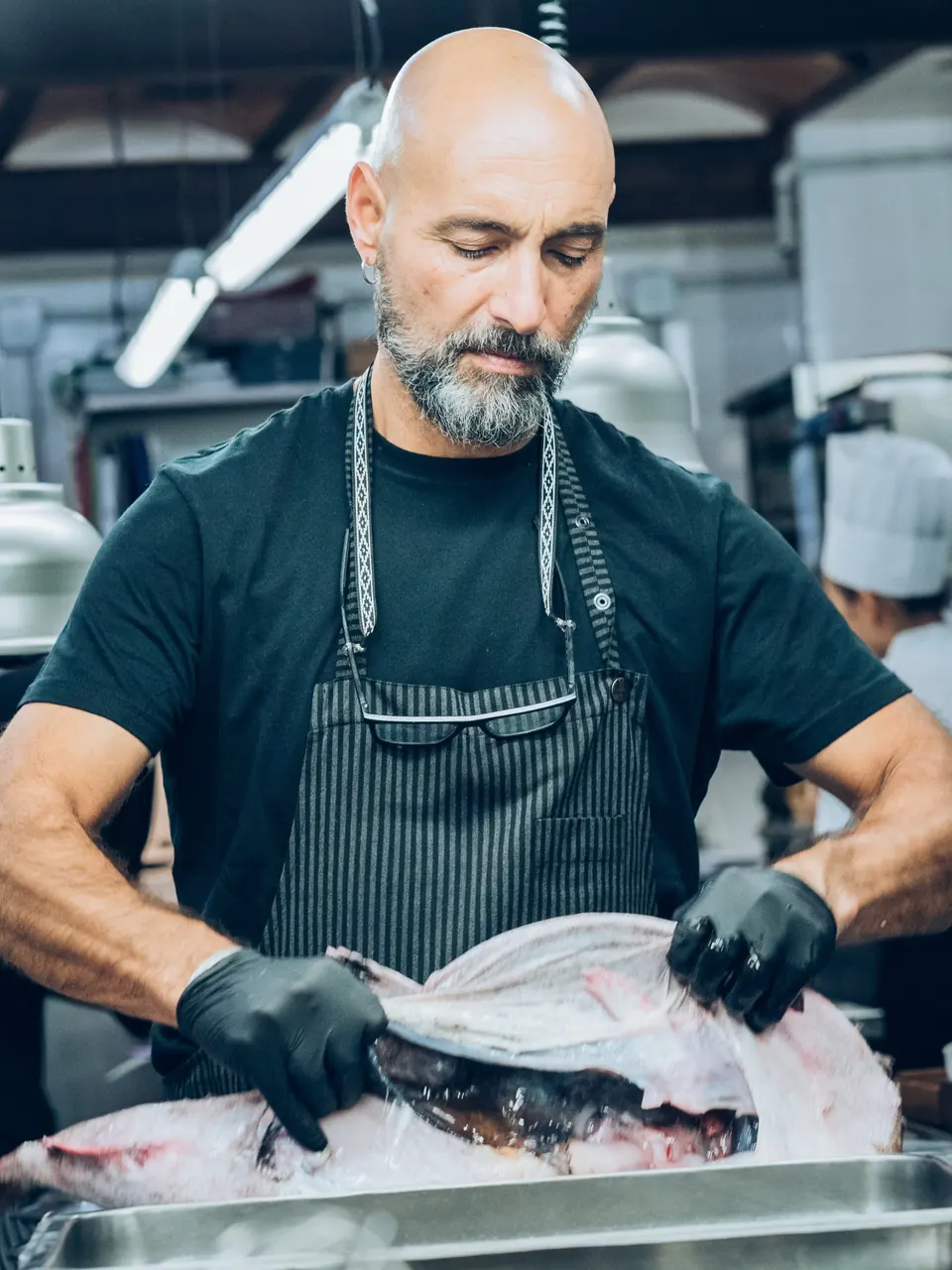 Benito Gómez limpiando un pescado en la cocina