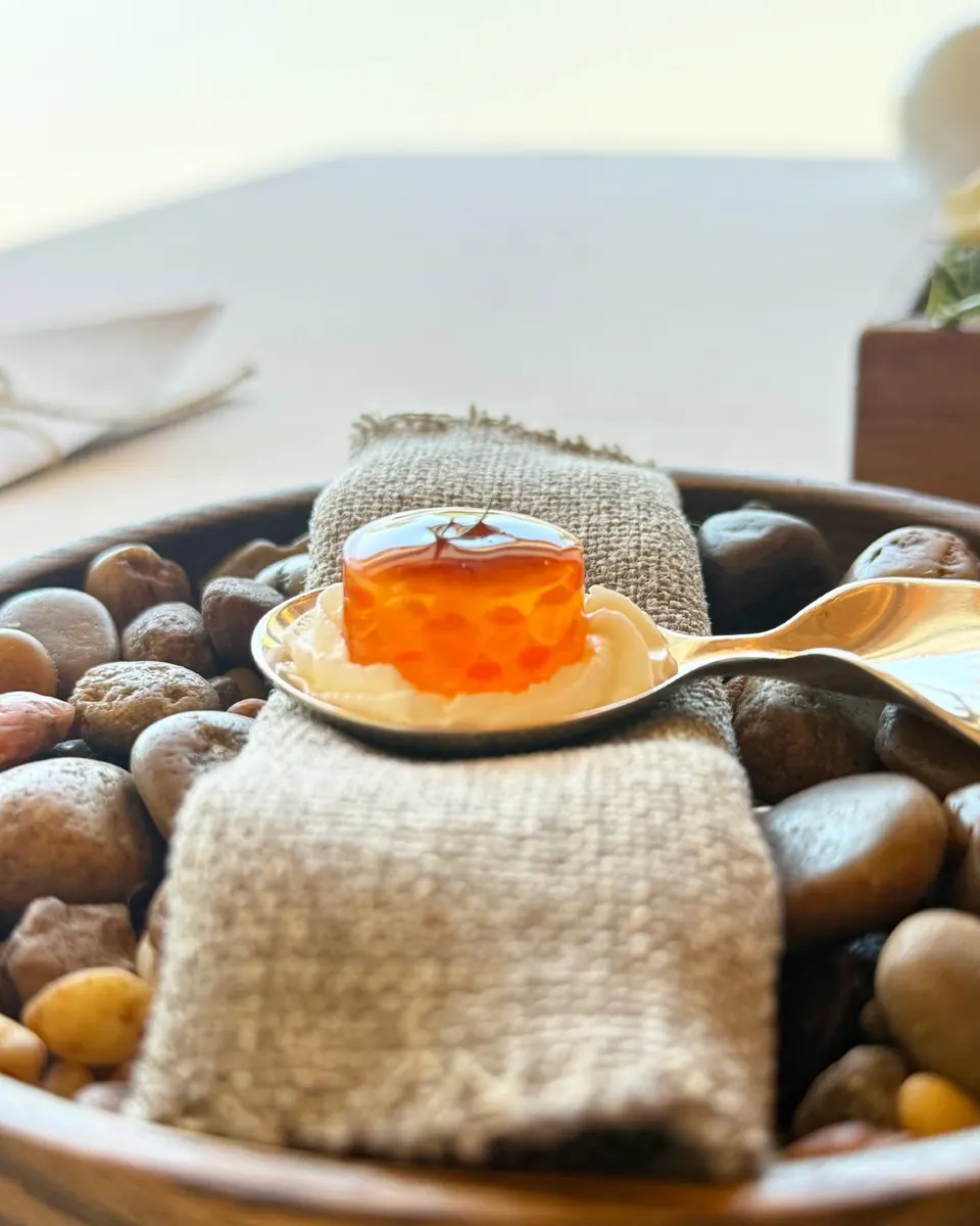 Una cuchara con un bocado servida sobre piedras