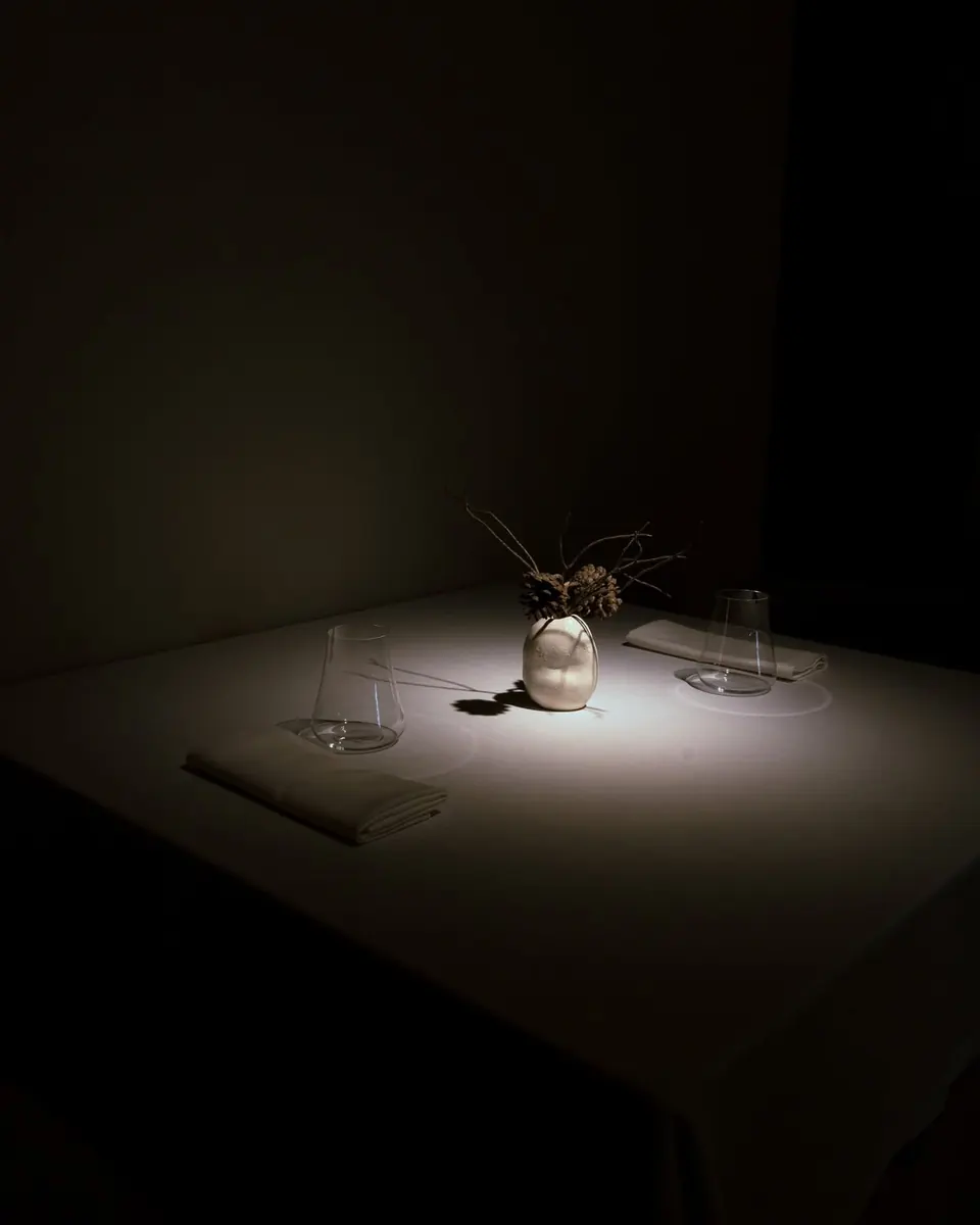 Una mesa de Bardal iluminada por un único haz de luz en la sala en penumbra